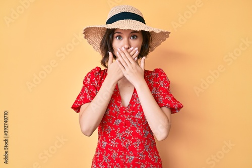 Young beautiful girl wearing summer hat shocked covering mouth with hands for mistake. secret concept.