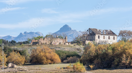View of ruined abandoned houses in the countryside with mountains in the background