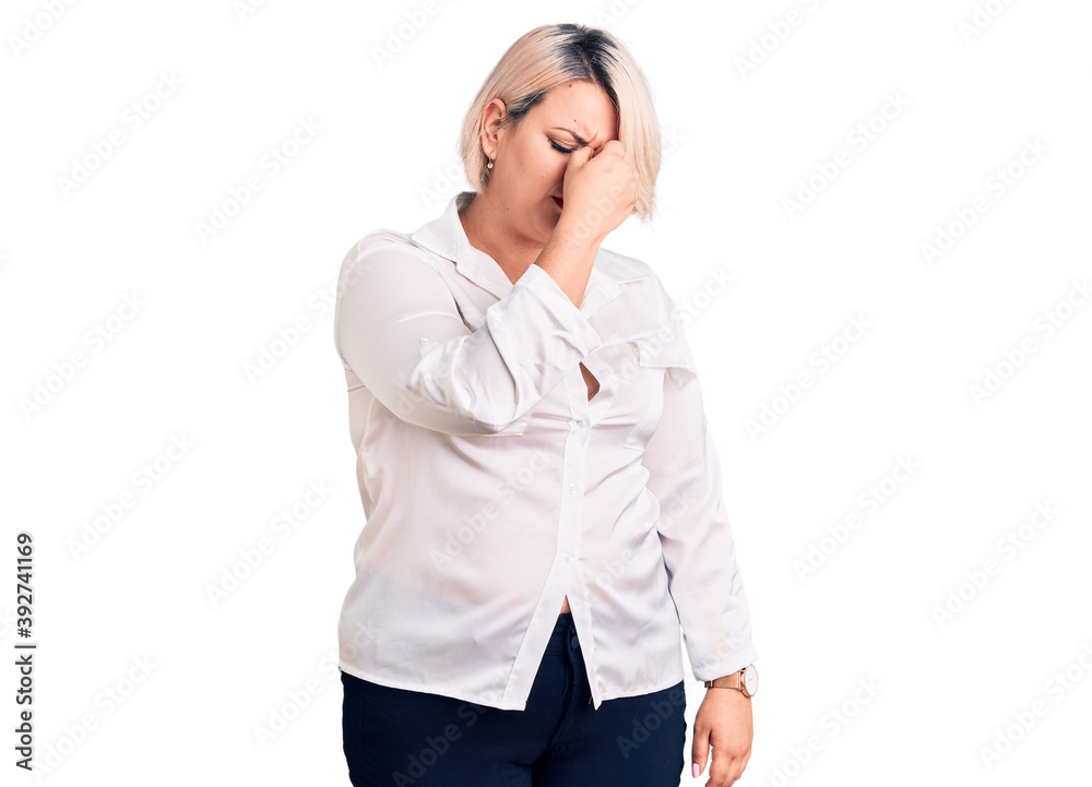 Young blonde plus size woman wearing casual shirt tired rubbing nose and eyes feeling fatigue and headache. stress and frustration concept. Young blonde plus size woman wearing casual shirt tired rubbing nose and eyes feeling fatigue and headache. stress and frustration concept.