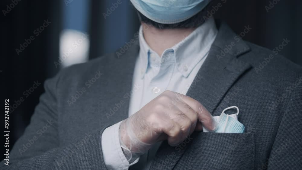 Businessman with face mask as square in suit pocket. Caucasian male business man wearing gloves and mask during Covid-19 pandemic Businessman with face mask as square in suit pocket. Caucasian male business man wearing gloves and mask during Covid-19 pandemic
