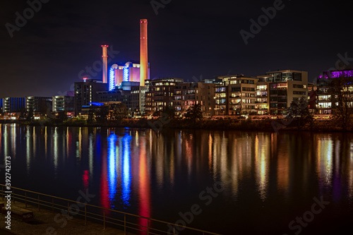 Westhafen in Frankfurt am Main bei Nacht vom südlichen Mainufer gesehen mit Wärmekraftwerk und Spieglungen im Wasser