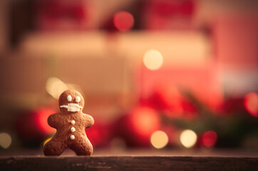 Gingerbread man on table with Christmas gifts on background