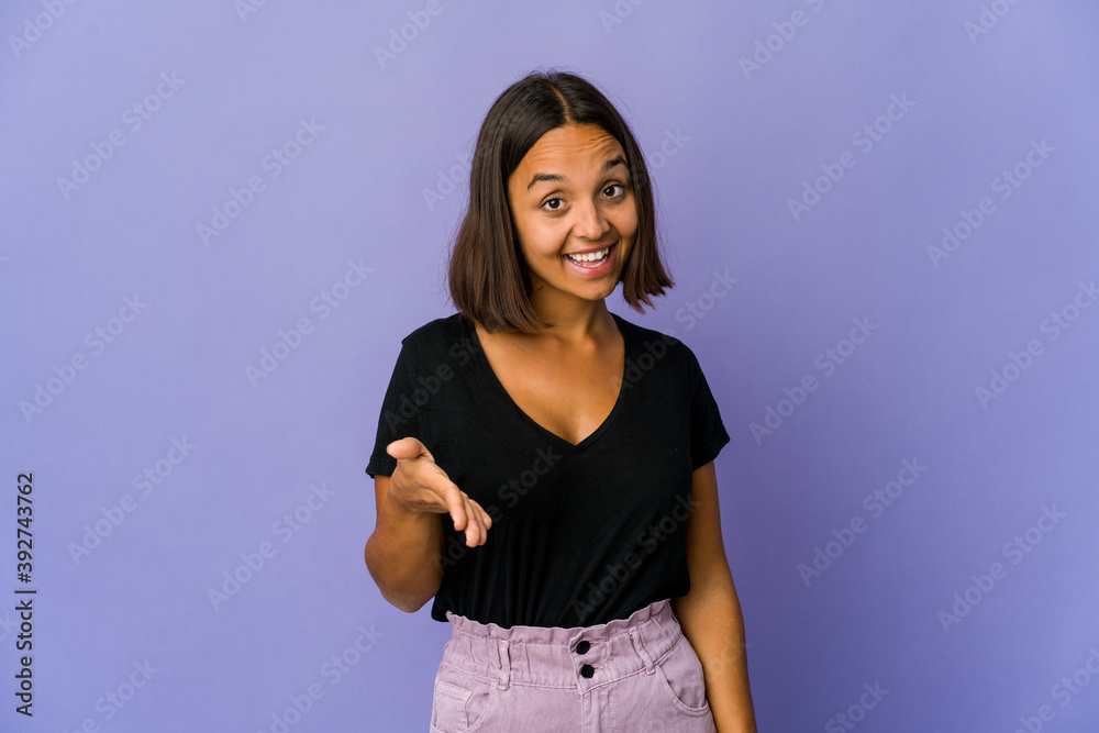 Young mixed race woman stretching hand at camera in greeting gesture. Young mixed race woman stretching hand at camera in greeting gesture.