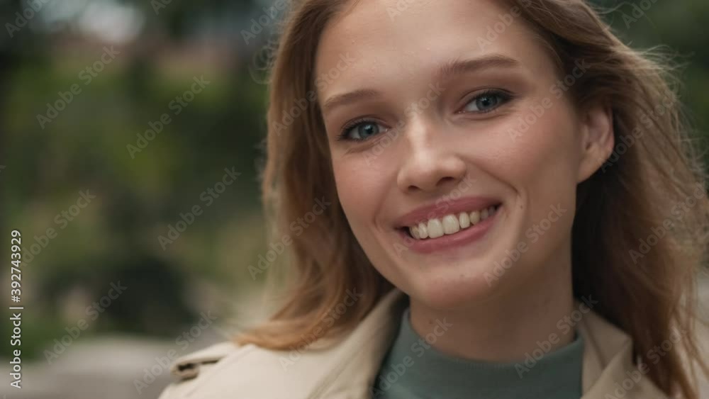 Close up pretty blond girl looking happy smiling on camera on street. Female student posing outdoor