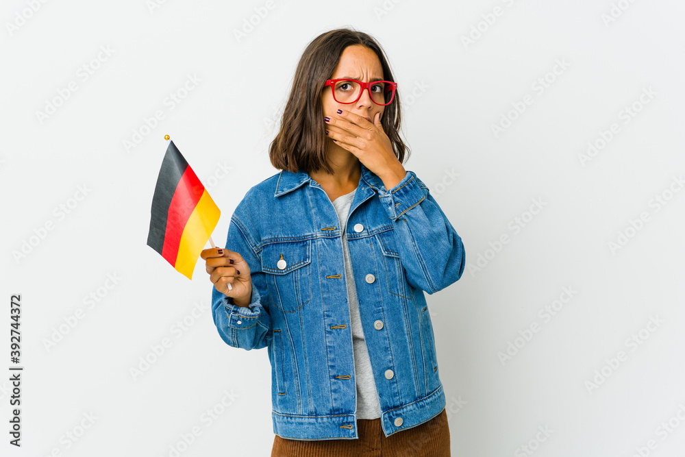 Young latin woman holding a german flag isolated on white background Young latin woman holding a german flag isolated on white background