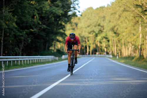 Cyclist doing sport among green forest