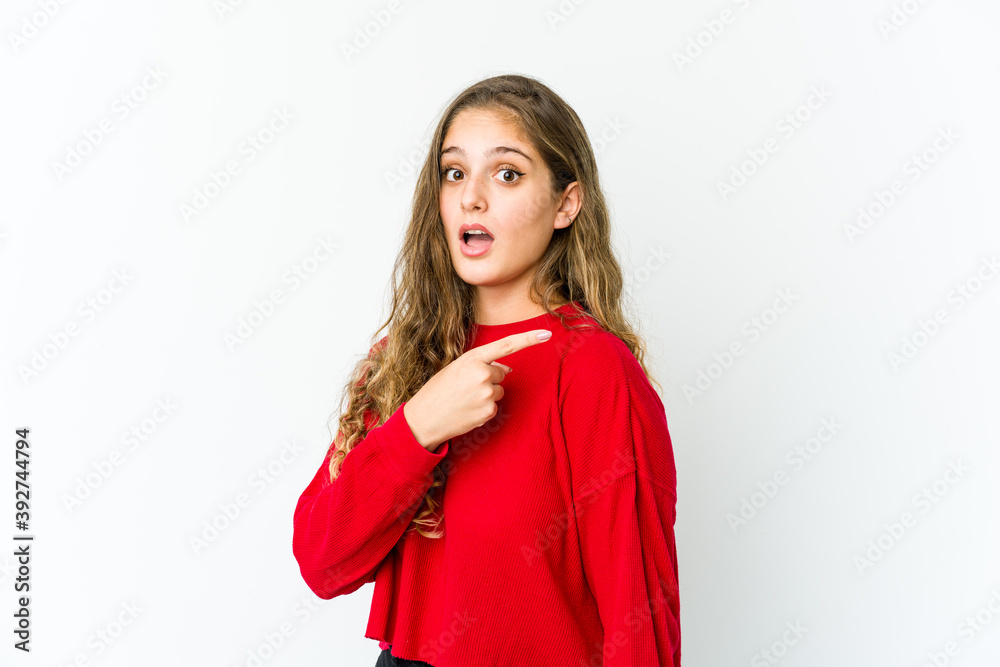 Young caucasian woman smiling and pointing aside, showing something at blank space. Young caucasian woman smiling and pointing aside, showing something at blank space.