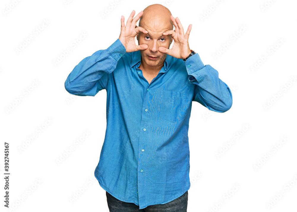 Fototapeta premium Middle age bald man wearing casual clothes trying to open eyes with fingers, sleepy and tired for morning fatigue