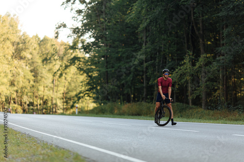 Active male in sport clothing riding bike on road