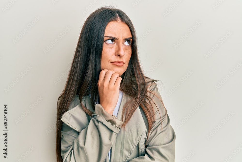 Beautiful hispanic woman wearing casual clothes thinking concentrated about doubt with finger on chin and looking up wondering Beautiful hispanic woman wearing casual clothes thinking concentrated about doubt with finger on chin and looking up wondering