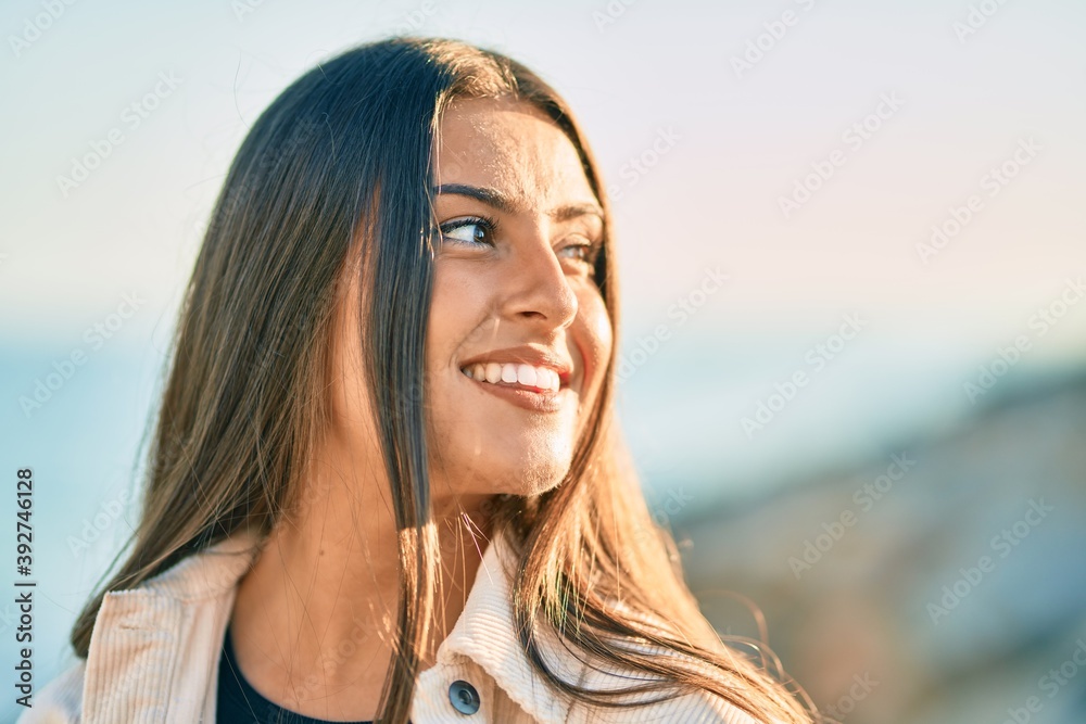 Young hispanic girl smiling happy standing at the promenade.