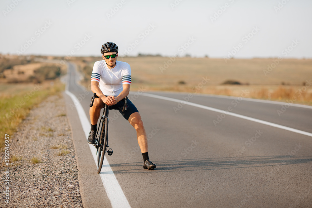 Handsome cyclist having break during morning ride outdoors