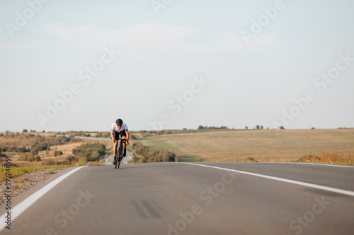 Strong man in helmet and glasses riding bike on fresh air