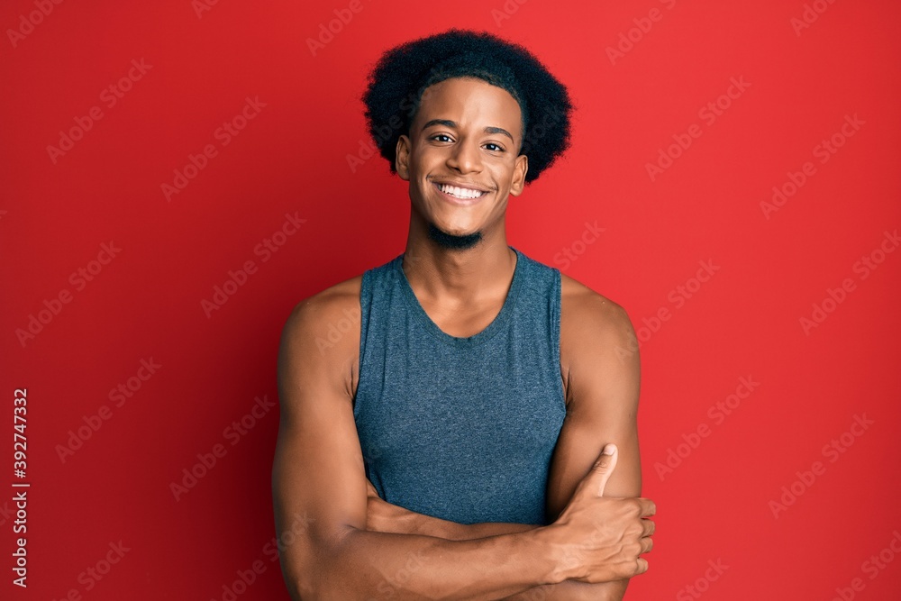 African american man with afro hair wearing sportswear happy face smiling with crossed arms looking at the camera. positive person. African american man with afro hair wearing sportswear happy face smiling with crossed arms looking at the camera. positive person.