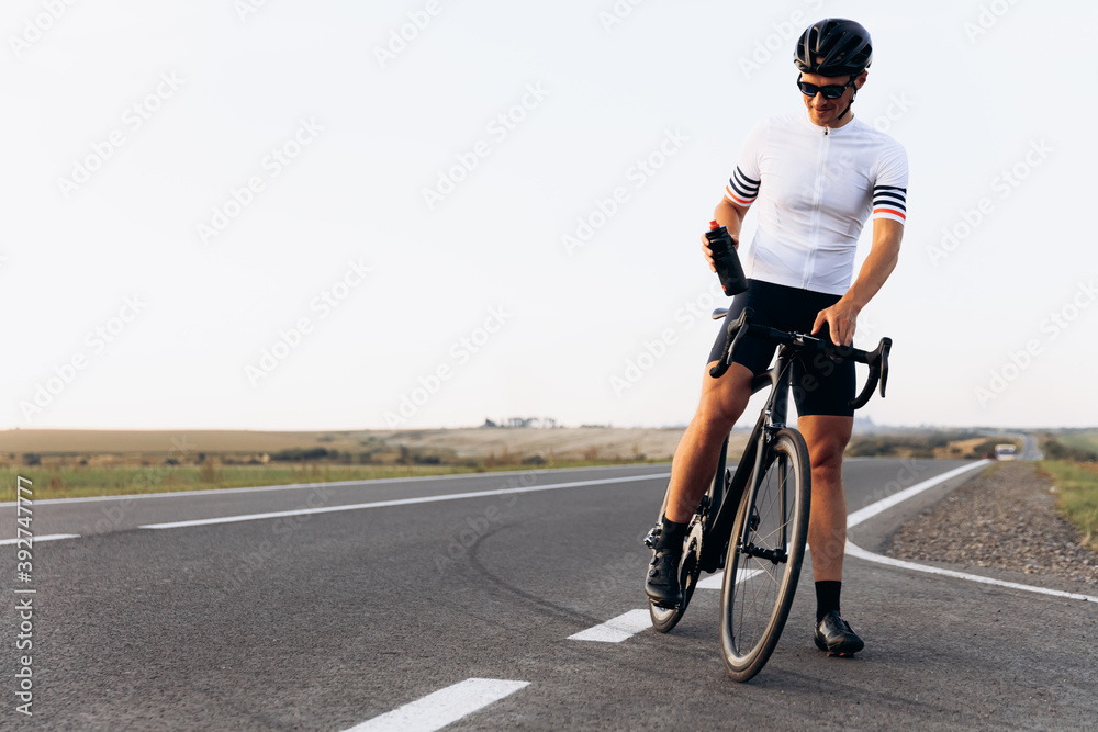 Obraz premium Happy cyclist in sport outfit standing outdoors