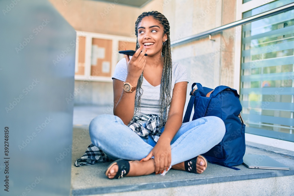 Young african american student woman smiling happy sending voice message using smartphone at the university campus Young african american student woman smiling happy sending voice message using smartphone at the university campus