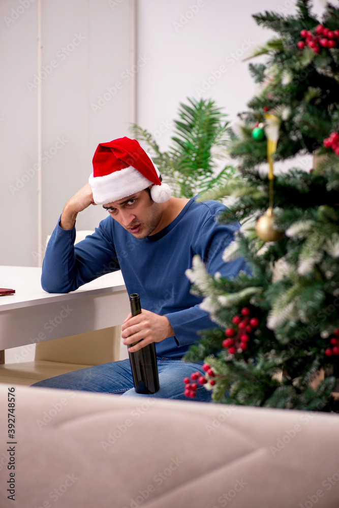 Young man celebrating Christmas alone at home Young man celebrating Christmas alone at home