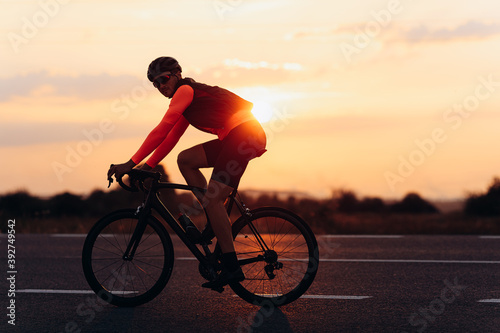 Sporty man in activewear riding bike on road