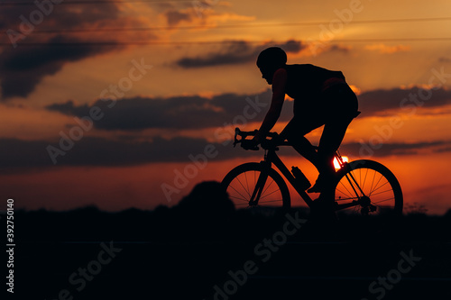 Fototapeta Naklejka Na Ścianę i Meble -  Silhouette of strong man racing on asphalt road