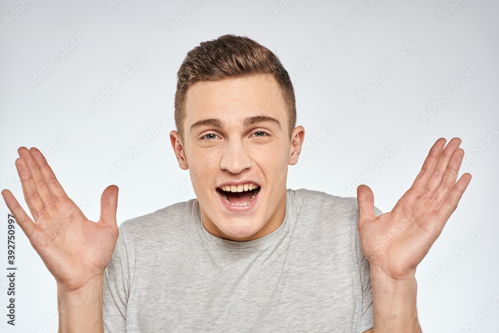Handsome man in gray t-shirt cropped view of emotion Studio Model Handsome man in gray t-shirt cropped view of emotion Studio Model