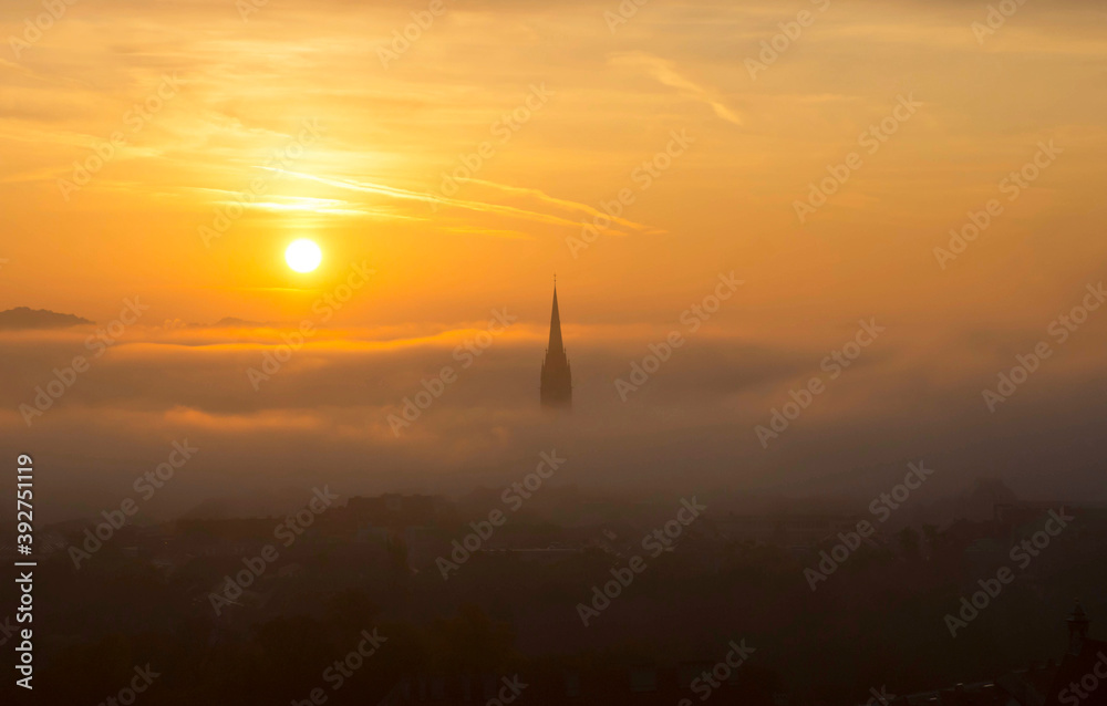 Cityscape of Graz with Church of the Sacred Heart of Jesus and historic buildings, in Graz, Styria region, Austria, at sunrise. Beautiful foggy morning over the city of Graz, in autumn