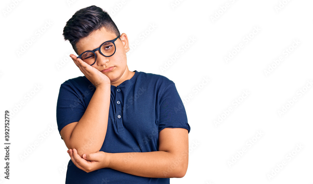 Little boy kid wearing casual clothes and glasses thinking looking tired and bored with depression problems with crossed arms. Little boy kid wearing casual clothes and glasses thinking looking tired and bored with depression problems with crossed arms.