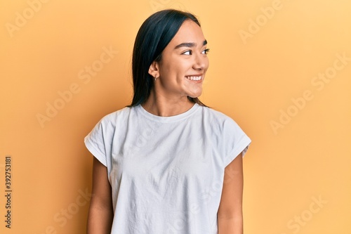 Young asian woman wearing casual white t shirt looking to side, relax profile pose with natural face and confident smile. © Krakenimages.com