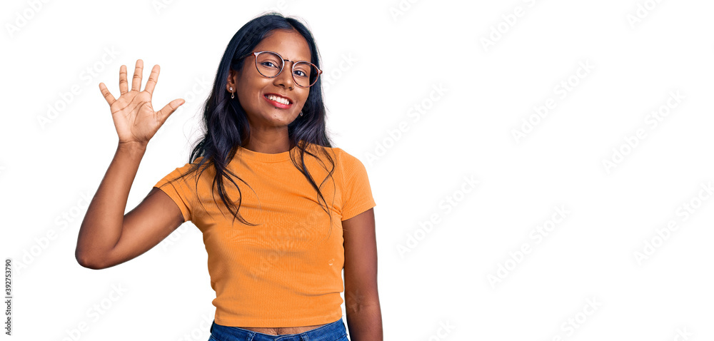 Young indian girl wearing casual clothes and glasses showing and pointing up with fingers number five while smiling confident and happy. Young indian girl wearing casual clothes and glasses showing and pointing up with fingers number five while smiling confident and happy.