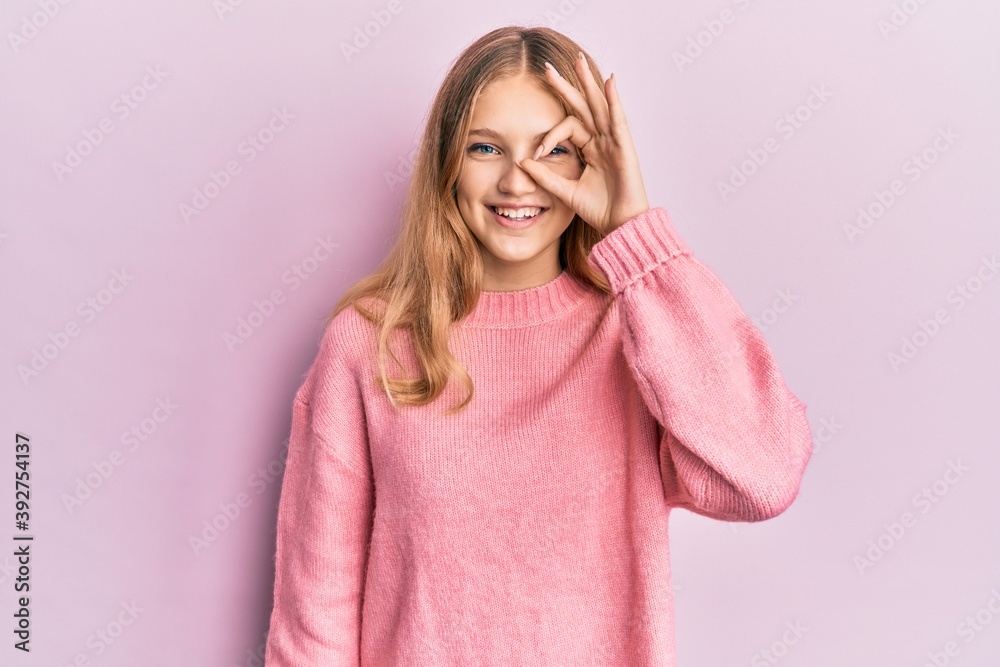 Beautiful young caucasian girl wearing casual clothes doing ok gesture with hand smiling, eye looking through fingers with happy face.
