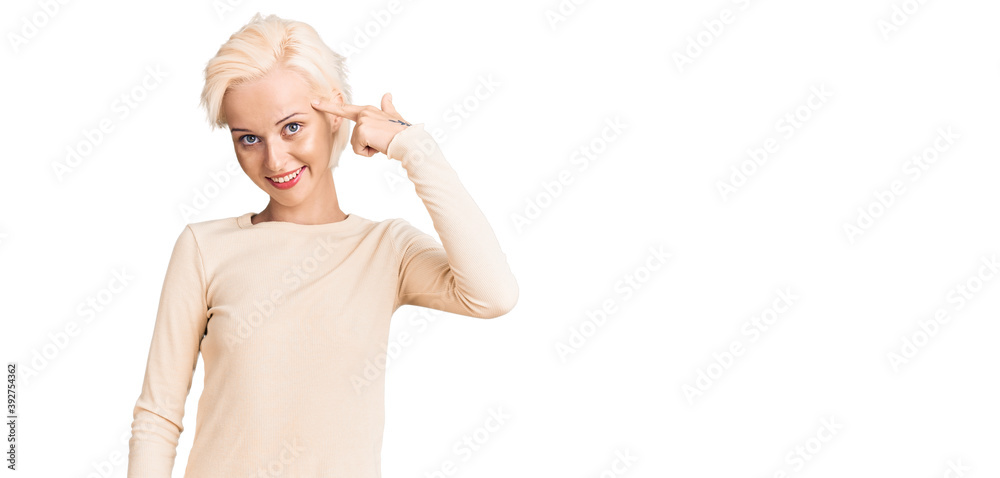 Young blonde woman wearing casual clothes smiling pointing to head with one finger, great idea or thought, good memory Young blonde woman wearing casual clothes smiling pointing to head with one finger, great idea or thought, good memory