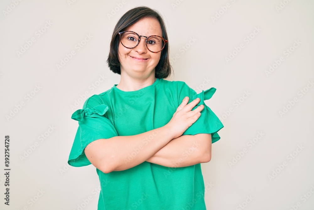 Brunette woman with down syndrome wearing casual clothes and glasses happy face smiling with crossed arms looking at the camera. positive person. Brunette woman with down syndrome wearing casual clothes and glasses happy face smiling with crossed arms looking at the camera. positive person.