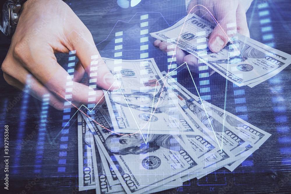 Multi exposure of financial graph drawing hologram and USA dollars bills and man hands. Analysis concept. Multi exposure of financial graph drawing hologram and USA dollars bills and man hands. Analysis concept.