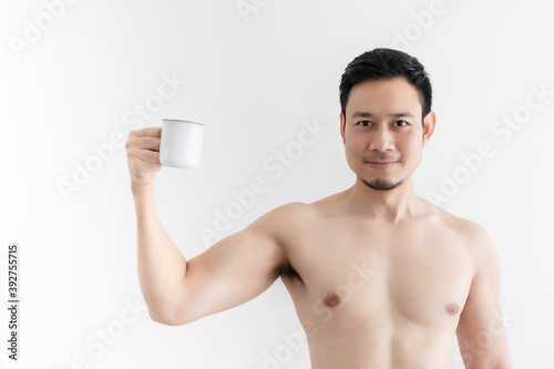 Topless healthy Asian man drinks the healthy coffee on isolated background.