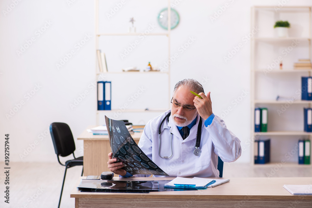 Old male doctor radiologist working in the hospital