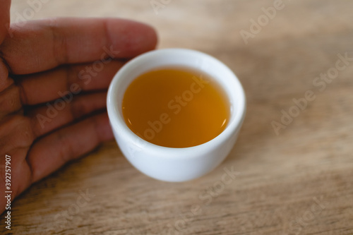 Closeup of hot tea in Chinese tea cup or Gaiwan on wooden table.