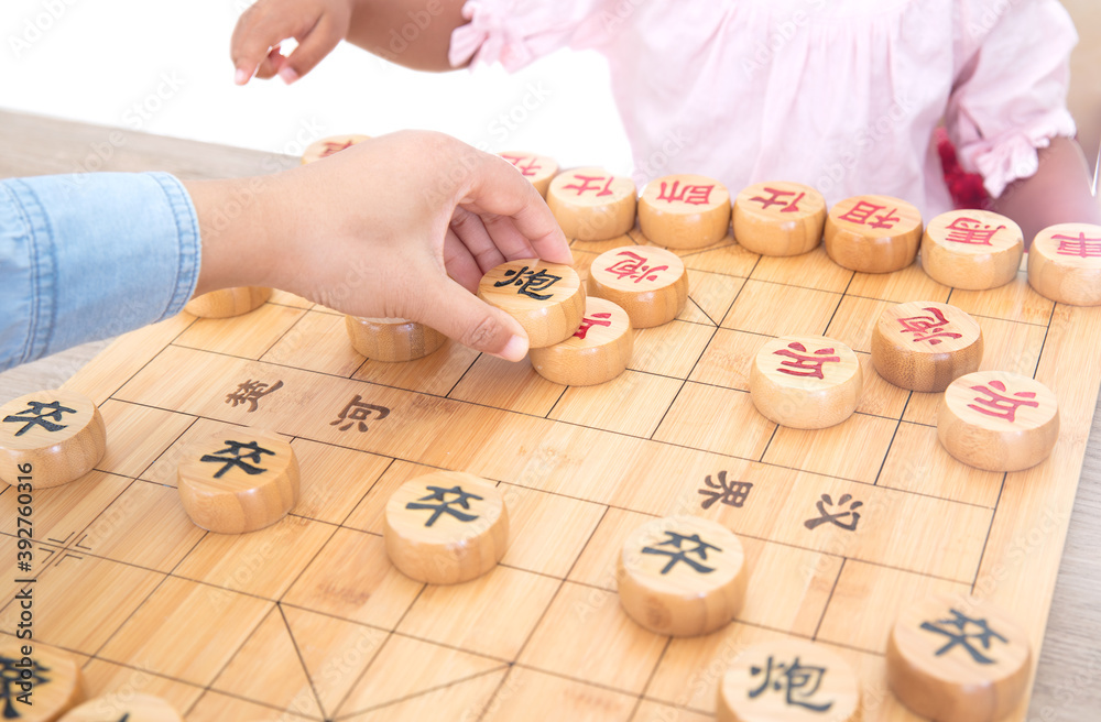Little girl playing Chinese chess with mother Little girl playing Chinese chess with mother