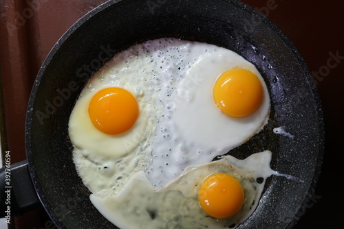 Fried eggs in a frying pan. Yellow yolks. The view from the top.