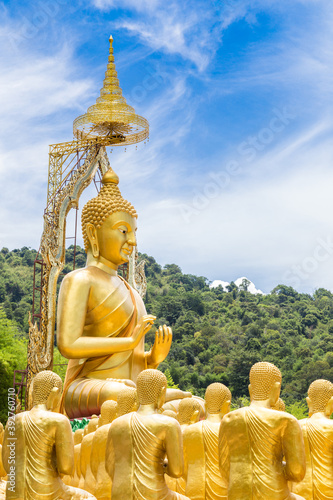 Row of disciple statues surrounding big buddha statue in public to the general public worship worship.