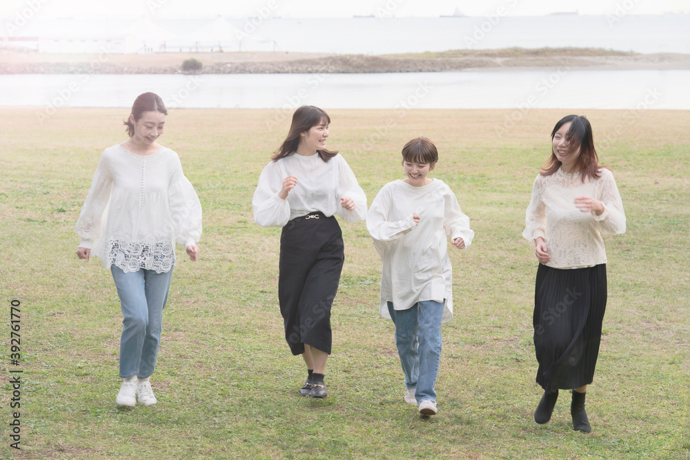 笑顔で話しながらゆっくり走る女性4人