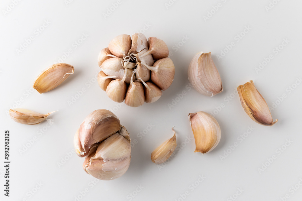 Garlic cloves and pieces of raw garlic on isolated white background. Top view Garlic bulbs.