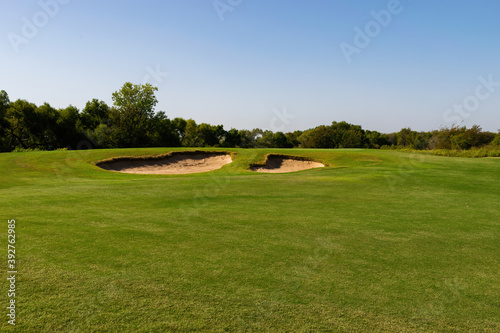 Two sands traps on a golf course fairway on a sunny day
