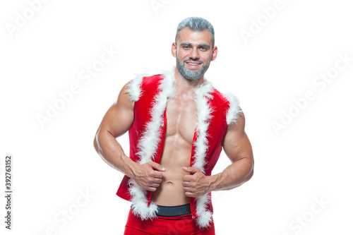 Sexy Santa Claus . Young muscular man wearing Santa Claus hat demonstrate his muscles. Isolated on white background.