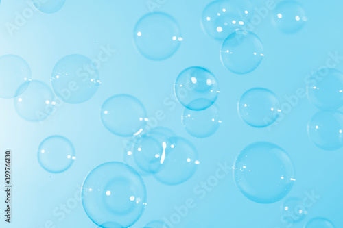 Beautiful shiny transparent soap bubbles float on blue texture background. Abstract  Celebration  Natual fresh summer  Chrimas holiday background.