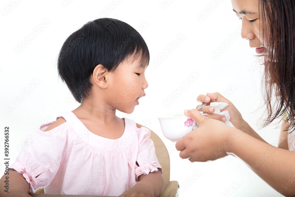 Young mother is feeding her cute daughter Young mother is feeding her cute daughter
