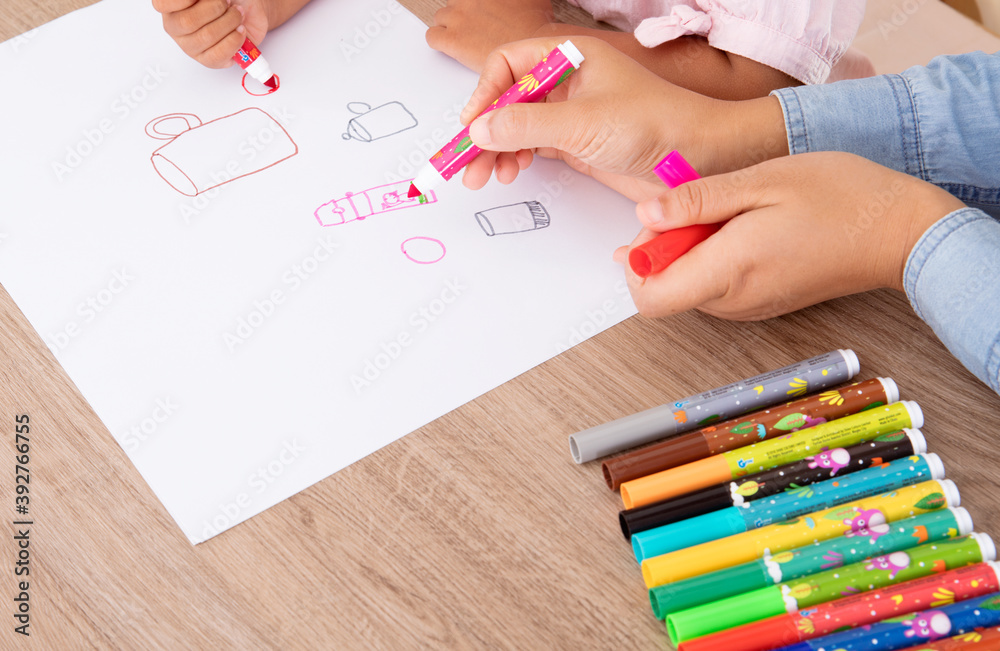 Kindergarten teacher is teaching children to draw simple strokes Stock