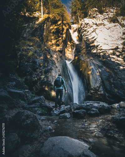 Waterfall in forest landscape long exposure flowing over rocks photo