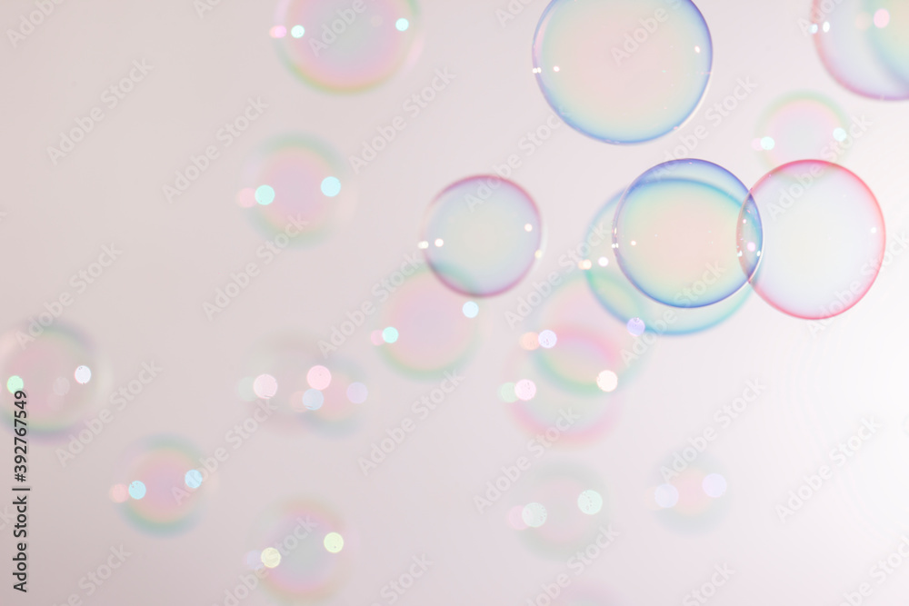 Beautiful shiny colorful soap bubbles floating on soft pink texture background. Abstract, Natual fresh summer background.
