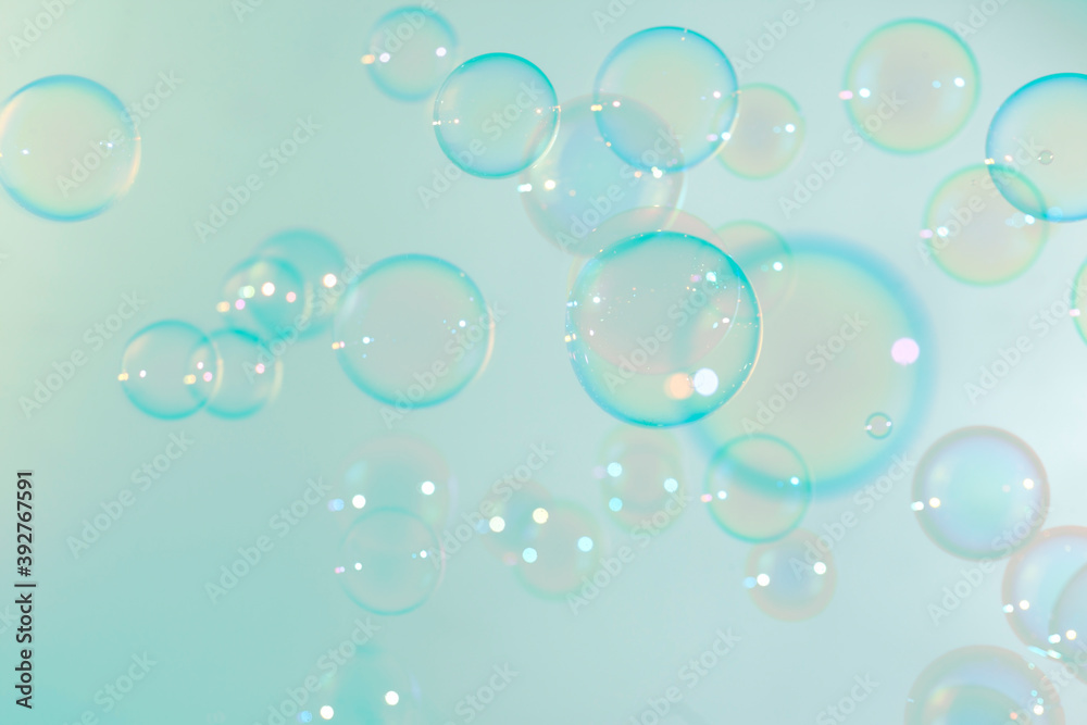 Abstract, Beautiful transparent soap bubbles float on soft green background. Natural freshness summer background.