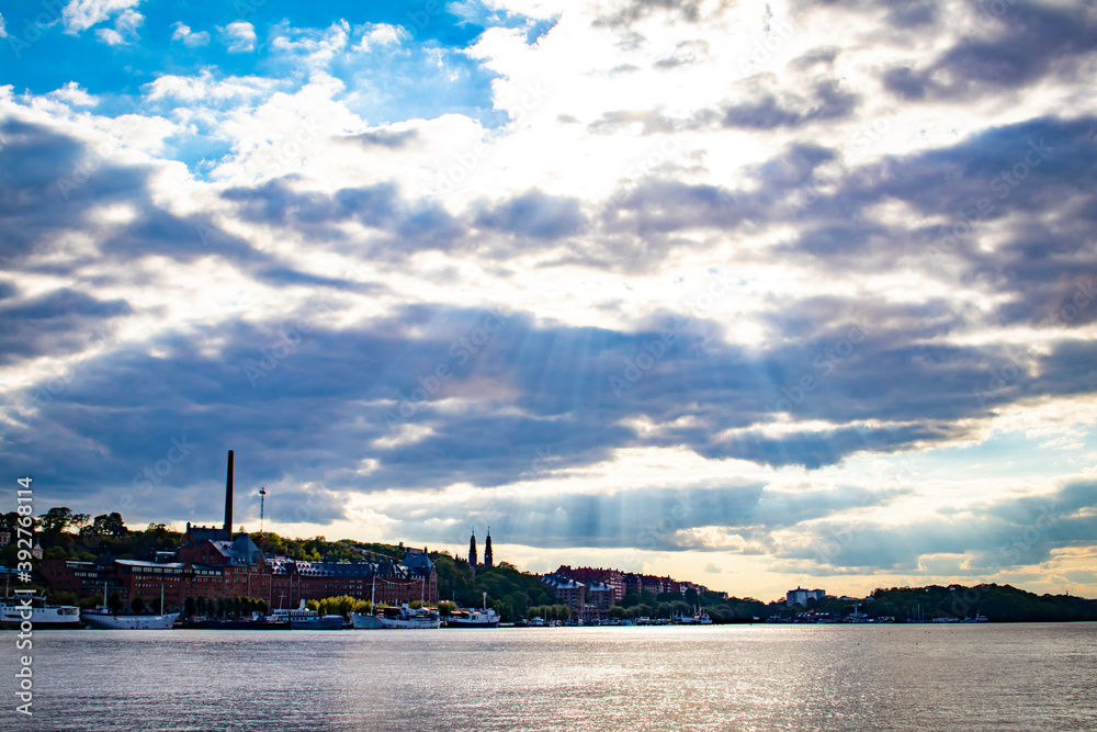 Sunlight Breaks through the Clouds and Shines on the Waterfront of the Katarina-Sofia Island in Stockholm, Sweden