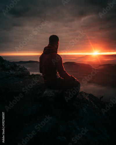man on mountain top watching the sunset © Maximilian